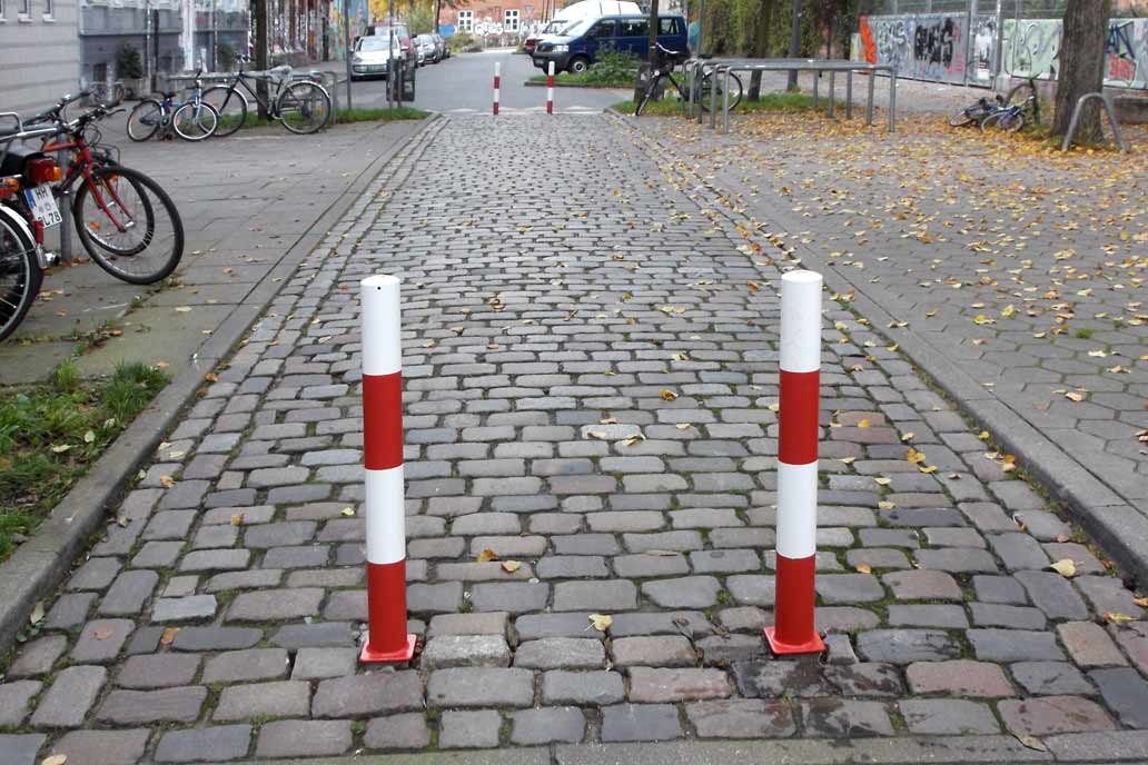 Zwei rot-weiße Poller als Straßenabsperrung.